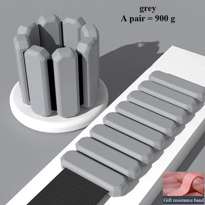 Gray cylindrical bandage roll with multiple rectangular gray bandages laid out diagonally on a white tray, plus a small inset showing a pink gift wrap band. Text reads 'grey A pair = 900 g' and 'Gift resistance band.
